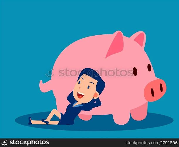 A businesswoman reclines close to the piggy bank. Saving money concept