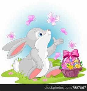 A cute Easter bunny sitting near Easter eggs basket.