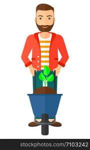 A hipster man standing with a plant and soil in a wheelbarrow vector flat design illustration isolated on white background. Vertical layout.. Man with plant and wheelbarrow.