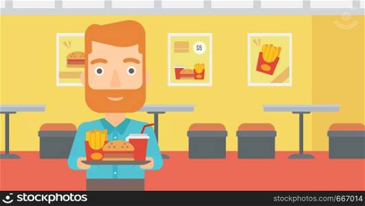 A hipster man with the beard holding a tray full of junk food on a cafe background vector flat design illustration. Horizontal layout.. Man with fast food.