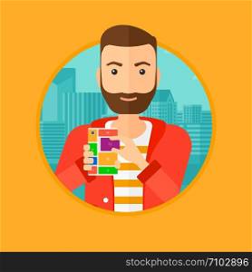 A hipster man with the beard holding modular phone. Young man with modular phone on a city background. Man using modular phone. Vector flat design illustration in the circle isolated on background.. Man with modular phone.