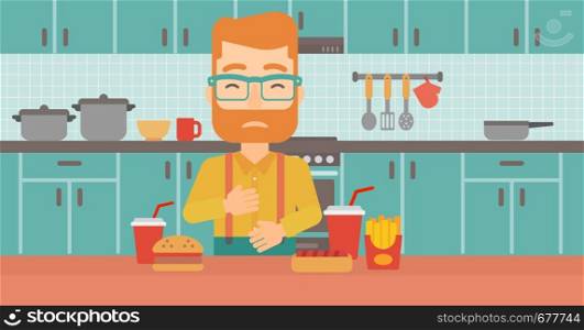 A hipster man with the beard standing in the kitchen in front of table full of junk food and suffering from heartburn vector flat design illustration. Horizontal layout.. Man suffering from heartburn.