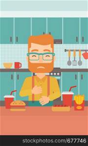 A hipster man with the beard standing in the kitchen in front of table full of junk food and suffering from heartburn vector flat design illustration. Vertical layout.. Man suffering from heartburn.
