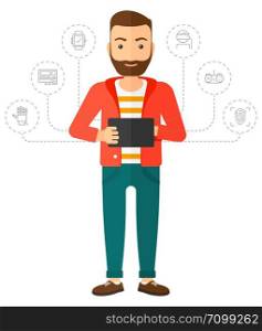 A hipster man with the beard standing with a tablet computer and some icons connected to the laptop vector flat design illustration isolated on white background. Vertical layout.. Man holding tablet computer.