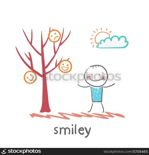 a man stands next to a tree on which grow smilies