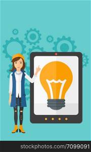 A woman pointing at a big tablet computer with a light bulb on a screen on a blue background with cogwheels vector flat design illustration. Vertical layout.. Woman pointing at tablet computer with light bulb on screen.