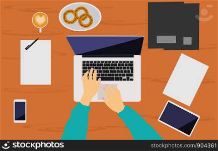 A woman's hand is working on a notebook placed on a brown wooden desk. There are phones, tablet, document file, coffee cups, and donuts as backgrounds.