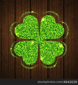 Abstract green glitter clover leaf on a wooden background