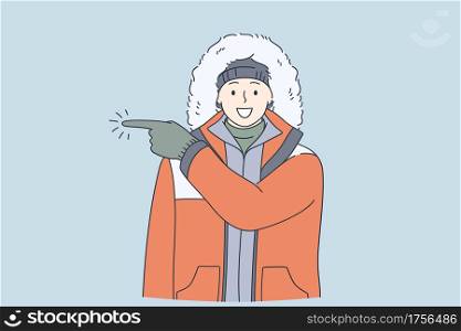 Adventurer, expedition, winter traveling concept. Young happy frozen man in warm clothes cartoon character having fun during winter pointing away with finger wearing gloves and warm clothes . Adventurer, expedition, winter traveling concept.
