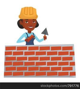 African-american bicklayer working with a spatula and a brick. Young confident bricklayer in uniform and hard hat. Bricklayer at work. Vector flat design illustration isolated on white background.. Bricklayer working with spatula and brick.