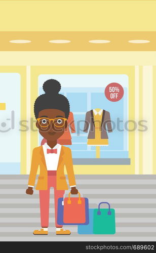 African-american woman holding shopping bags on the background of boutique window with dressed mannequins. Happy young woman carrying shopping bags. Vector flat design illustration. Vertical layout.. Happy woman with bags vector illustration.