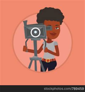 African cameraman looking through movie camera on a tripod. Cameraman with professional video camera. Cameraman taking a video. Vector flat design illustration in the circle isolated on background.. Cameraman with movie camera on tripod.