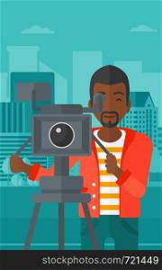 An african-american cameraman looking through movie camera on a city background vector flat design illustration. Vertical layout.. Cameraman with movie camera on a tripod.