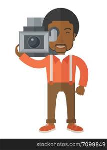 An african-american cameraman with video camera taking a video vector flat design illustration isolated on white background. Vertical layout.. Cameraman.