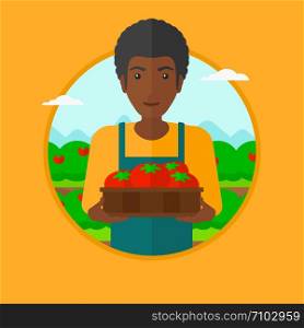 An african-american farmer holding a box with tomatoes. Happy farmer standing on the background of field with bushes of tomatoes. Vector flat design illustration in the circle isolated on background.. Farmer collecting tomatos vector illustration.