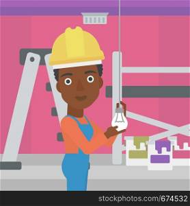 An african-american female worker twisting a light bulb on a background of room with paint cans and ladder vector flat design illustration isolated on white background. Square layout.. Electrician twisting light bulb.