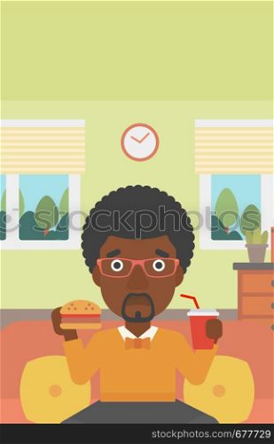 An african-american man sitting on a sofa while eating hamburger and drinking soda on the background of living room vector flat design illustration. Vrtical layout.. Man eating hamburger.