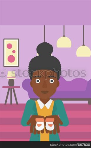An african-american pregnant woman holding baby booties in hands on the background of living room. Vector flat design illustration. Vertical layout.. Pregnant woman with baby booties.
