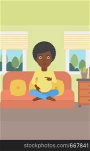 An african-american pregnant woman holding her hands on belly. Young pregnant woman sitting on a sofa at home. Vector flat design illustration. Vertical layout.. Happy pregnant woman.