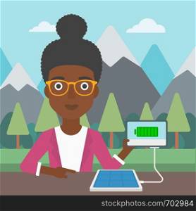 An african-american woman charging tablet computer with solar panel on a background of mountains. Charging digital tablet from portable solar panel. Vector flat design illustration. Square layout.. Solar panel charging tablet computer.