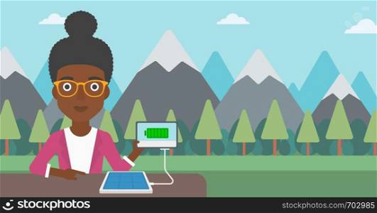 An african-american woman charging tablet computer with solar panel on a background of mountains. Charging digital tablet from portable solar panel. Vector flat design illustration. Horizontal layout.. Solar panel charging tablet computer.