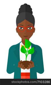 An african-american woman holding in hands a small plant in soil vector flat design illustration isolated on white background. . Woman holding plant.