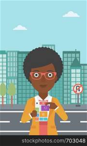An african-american woman holding modular phone. Woman with modular phone standing on a city background. Woman using modular phone. Vector flat design illustration. Vertical layout.. Woman with modular phone vector illustration.
