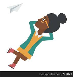 An african-american woman lying on a cloud and looking at flying paper plane vector flat design illustration isolated on white background. . Business woman relaxing on cloud.