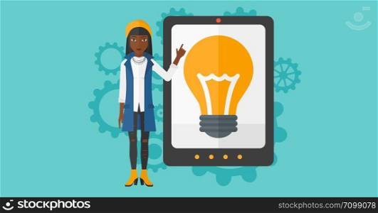 An african-american woman pointing at a big tablet computer with a light bulb on a screen on a blue background with cogwheels vector flat design illustration. Horizontal layout.. Woman pointing at tablet computer with light bulb on screen.