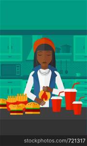 An african-american woman standing in front of table full of junk food and suffering from heartburn on a kitchen background vector flat design illustration. Vertical layout.. Woman suffering from heartburn.