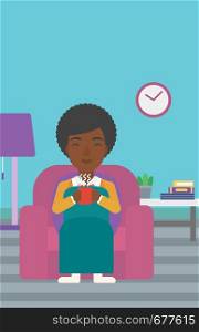 An african-american woman wrapped into a plaid sitting in chair in living room and holding a cup of hot flavored tea vector flat design illustration. Vertical layout.. Woman sitting in chair with cup of tea.