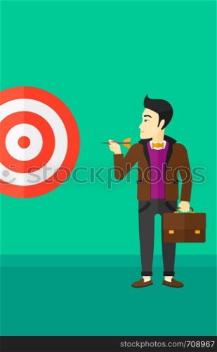 An asian businessman standing with arrow in hand and aiming at a target board on a green background vector flat design illustration. Vertical layout.. Businessman with target board.