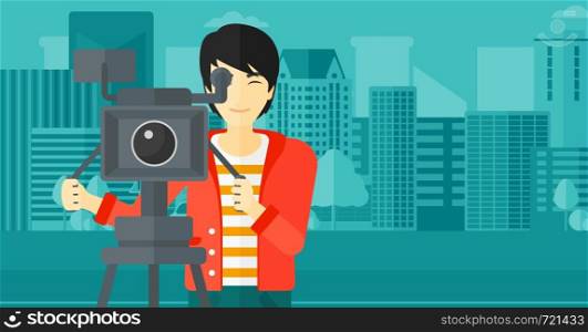 An asian cameraman with the beard looking through movie camera on a city background vector flat design illustration. Horizontal layout.. Cameraman with movie camera on a tripod.