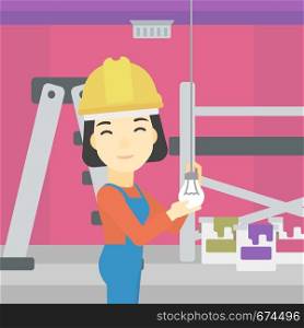 An asian female electrician twisting a light bulb. An electrician installing light in an apartment. Electrician changing light bulb. Vector flat design illustration. Square layout.. Electrician twisting light bulb.