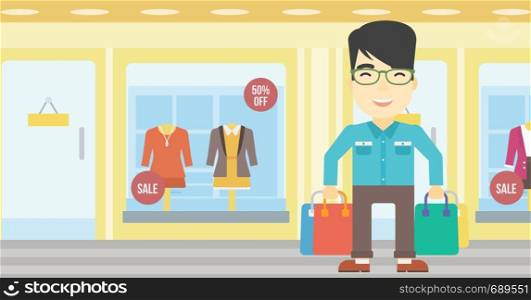 An asian man holding shopping bags on the background of boutique window with dressed mannequins. Happy young man carrying shopping bags. Vector flat design illustration. Horizontal layout.. Happy man with shopping bags vector illustration.