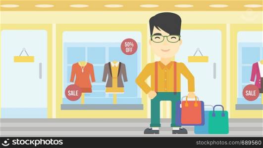 An asian man holding shopping bags on the background of boutique window with dressed mannequins. Happy young man carrying shopping bags. Vector flat design illustration. Horizontal layout.. Happy man with shopping bags vector illustration.