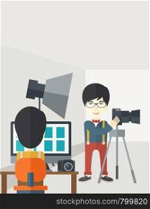 An asian photographer stands with camera while another man sits in front of monitor in studio vector flat design illustration. Vertical layout with a text space.. Photographers in studio.