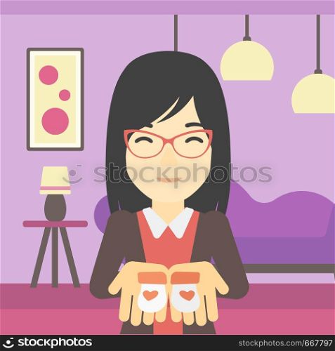 An asian pregnant woman holding baby booties in hands on the background of living room. Vector flat design illustration. Square layout.. Pregnant woman with baby booties.