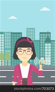 An asian woman holding ringing mobile phone on a city background. Woman answering a phone call. Woman with ringing phone in hand. Vector flat design illustration. Vertical layout.. Woman holding ringing telephone.