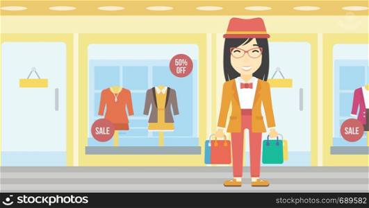 An asian woman holding shopping bags on the background of boutique window with dressed mannequins. Happy young woman carrying shopping bags. Vector flat design illustration. Horizontal layout.. Happy woman with bags vector illustration.
