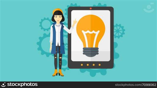 An asian woman pointing at a big tablet computer with a light bulb on a screen on a blue background with cogwheels vector flat design illustration. Horizontal layout.. Woman pointing at tablet computer with light bulb on screen.