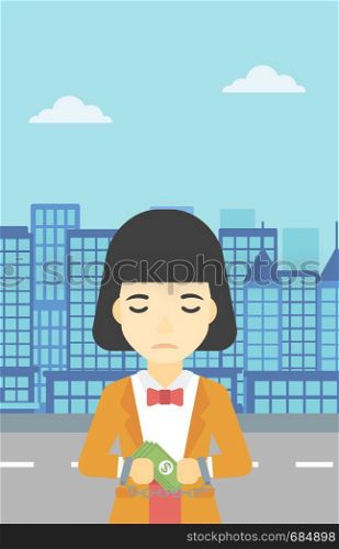 An asian young business woman in handcuffs with money in hands on the background of modern city. Business woman handcuffed for crime. Vector flat design illustration. Vertical layout.. Business woman handcuffed for crime.
