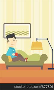 An asian young man lying on sofa in living room and holding a cup of hot flavored tea. Vector flat design illustration. Vertical layout.. Man lying with cup of tea vector illustration.