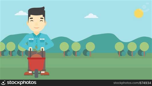 An asian young man standing with a plant and soil in a wheelbarrow on the background of mountain landscape. Vector flat design illustration. Horizontal layout.. Man with plant and wheelbarrow.