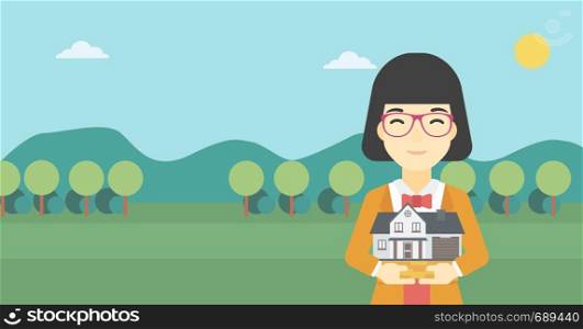 An asian young woman holding house model in hands on the background of mountains. Real estate agent with house model in hands. Vector flat design illustration. Horizontal layout.. Woman holding house model vector illustration.