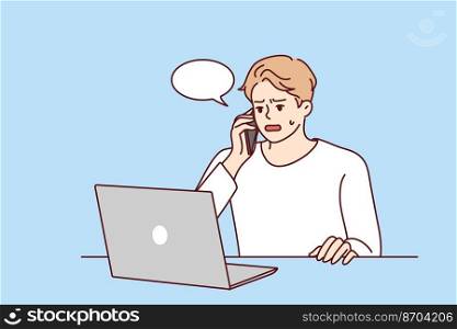 Angry young man sit at desk work on computer talk on cell about problem on device. Unhappy male experience trouble using laptop speak with helpline. Vector illustration. . Unhappy man speak with helpline having computer problem 