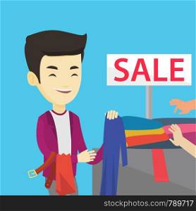 Asian smiling man choosing clothes in shop on sale. Happy male customer buying clothes at the store on sale. Young man shopping in clothes shop on sale. Vector flat design illustration. Square layout.. Young man choosing clothes in shop on sale.