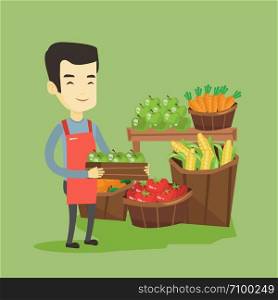 Asian worker of grocery store standing in front of section with vegetables and fruits. Young worker of grocery store holding a box with apples. Vector flat design illustration. Square layout.. Supermarket worker with box full of apples.