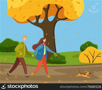 Autumn park, yellow trees, bushes, falling leaves, young warmly dressed couple walking cheerful little dog on leash. Happy pet. Woman and man are holding hands. Family in various weather conditions. People walk dog on leash, autumn park or countryside, fall leaves, yellow trees, bushes. Autumn time