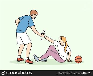 Basketball caviar helps fallen girl to stand up, showing team solidarity with injured opponent. Responsive friend lending helping hand to friend sitting on ground near basketball ball. Basketball caviar helps fallen girl to stand up, showing team solidarity with injured opponent